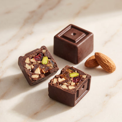 Bite de Oribo partido por la mitad: almendra, dátil, pistacho y arándano bajo el chocolate negro